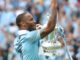 Raheem Sterling with Manchester City celebrates with the FA Cup Trophy in 2019