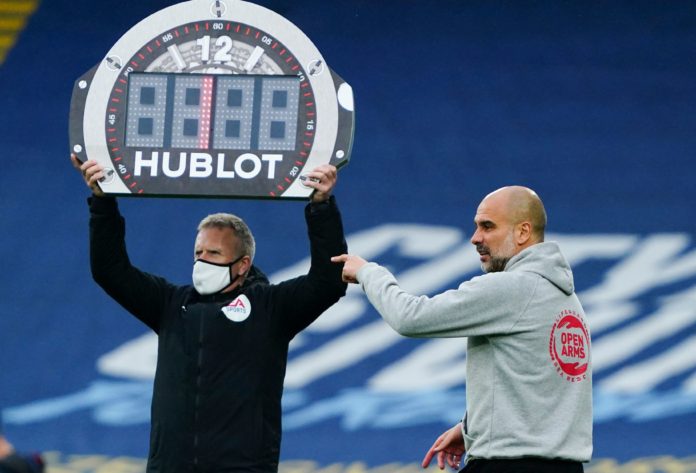 Manchester City Manager Pep Guardiola points as fourth official Jon Moss holds up the Hublot substitutes board in 2021