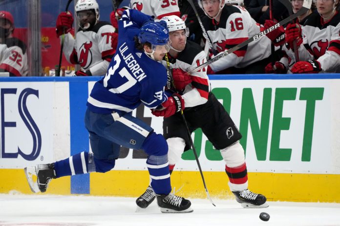 Maple Leafs' Timothy Liljegren (37) in a duel with Devils forward Andreas Johnsson (11)