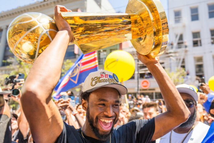 Andrew Wiggins holds the Larry O'Brien Trophy during the Golden State Warriors Championship Parade in 2022