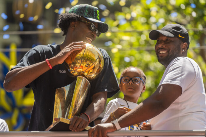 Jonathan Kuminga holds the Larry O'Brien Trophy on a float during the Golden State Warriors Championship Parade in 2022