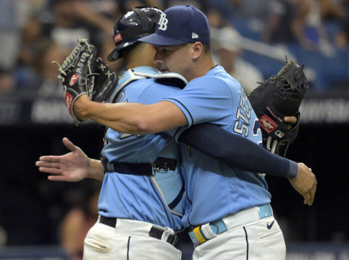 Tampa Bay Rays reliever Robert Stephenson (R) hugs catcher Christian Bethancourt in July 2023