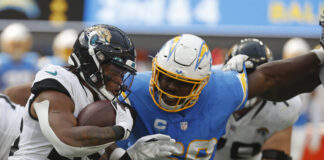 Jacksonville Jaguars running back James Robinson (25) carries the ball and is tackled by Los Angeles Chargers defensive tackle Sebastian Joseph-Day (69) in 2022