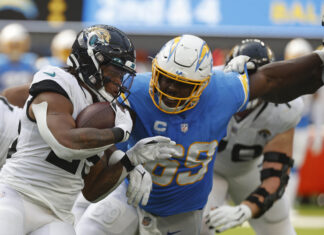 Jacksonville Jaguars running back James Robinson (25) carries the ball and is tackled by Los Angeles Chargers defensive tackle Sebastian Joseph-Day (69) in 2022
