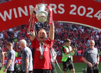 Jonny Evans lifting The FA Cup Trophy after The Emirates FA Cup Final soccer match between Manchester City and Manchester United in May 2024