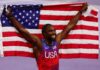 Noah Lyles of USA wins Gold and celebrates with the USA flag during the Men's 100m Final Paris 2024 Olympic Games in August 2024