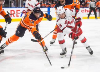Carolina Hurricanes' Seth Jarvis (24) and Edmonton Oilers' William Lagesson (84) in December 2021